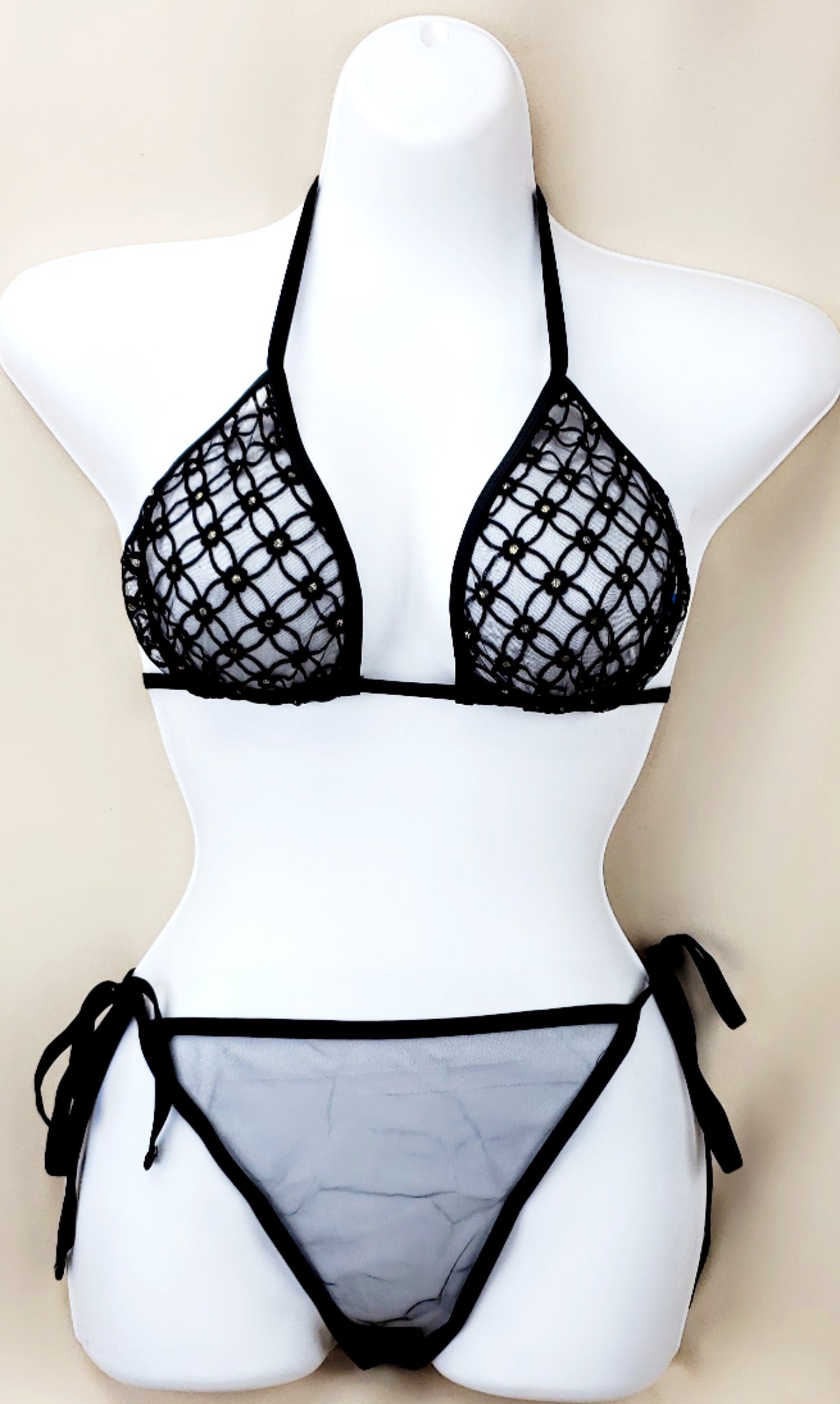 Black fishnet lace bikini set on a mannequin, featuring a triangle top with diamond embellishments and tie-side bottoms.