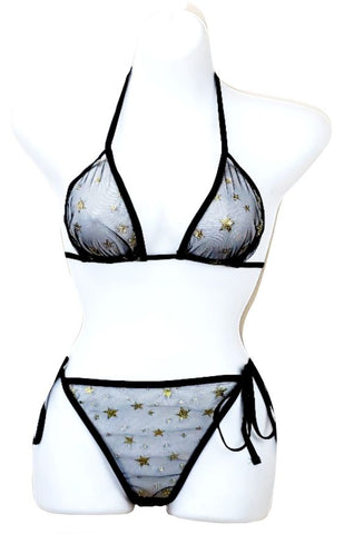 The image features a Black Sheer Gold Star Bikini Set displayed on a mannequin. The bikini consists of a sheer black fabric adorned with gold star embellishments.